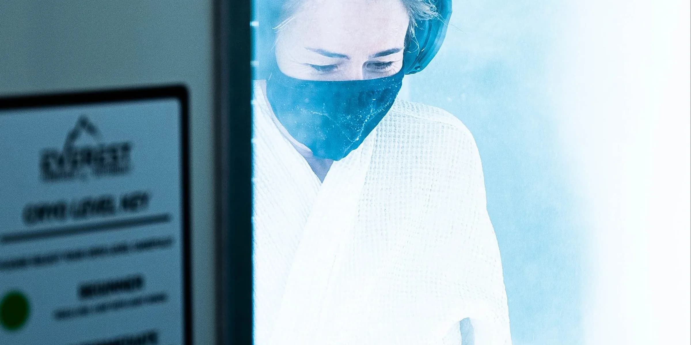 Whole-body cryotherapy client in a bright cold recovery chamber.