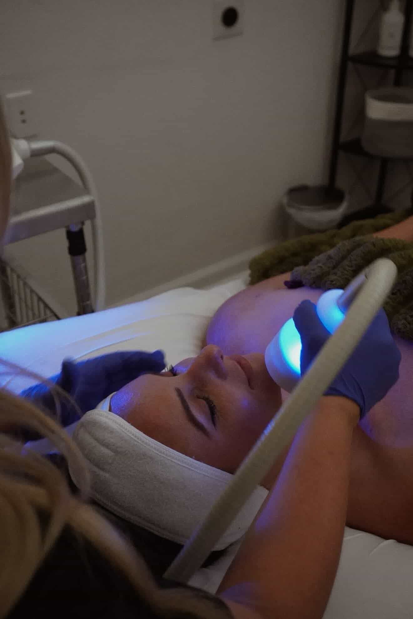 Face-focused skin device detail in a warm aesthetics room.