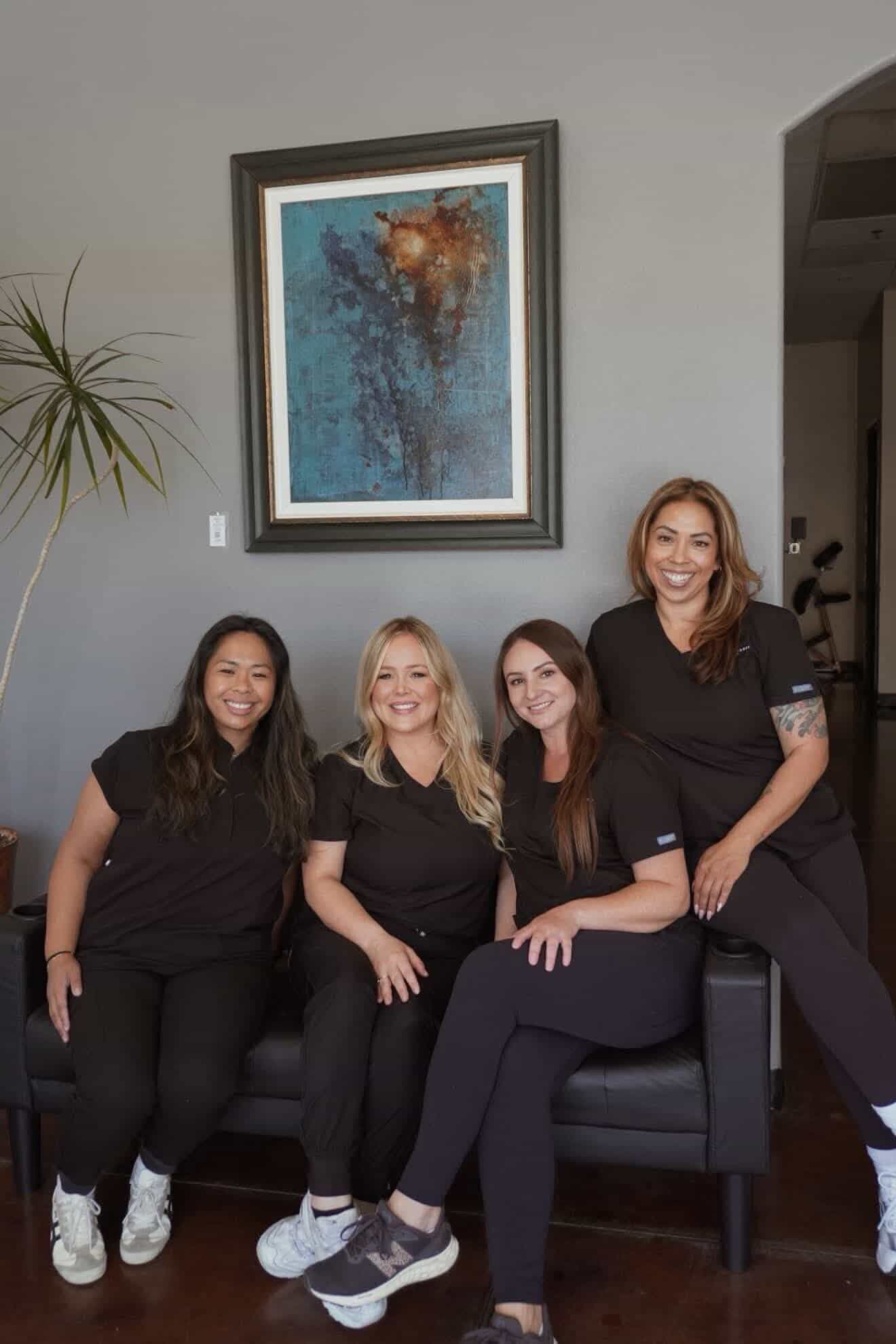 SK Longevity team portrait in black scrubs against a bright studio wall.