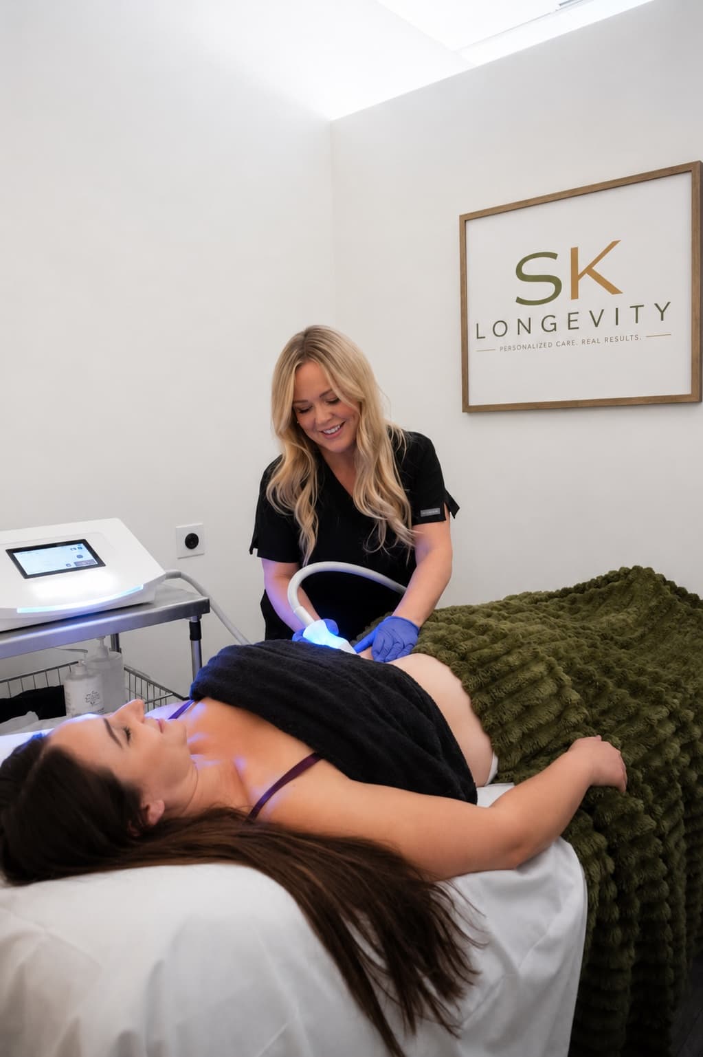 Cryoskin slimming treatment on a client's abdomen in an SK Longevity treatment room.