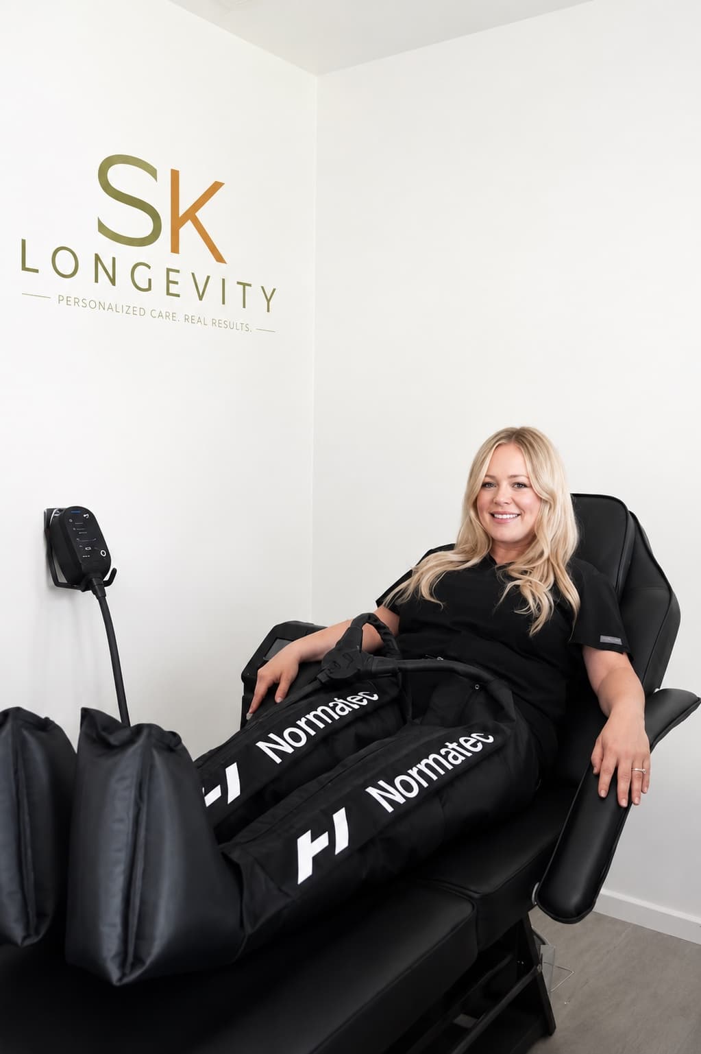 Client using Normatec compression boots in an SK Longevity recovery chair.