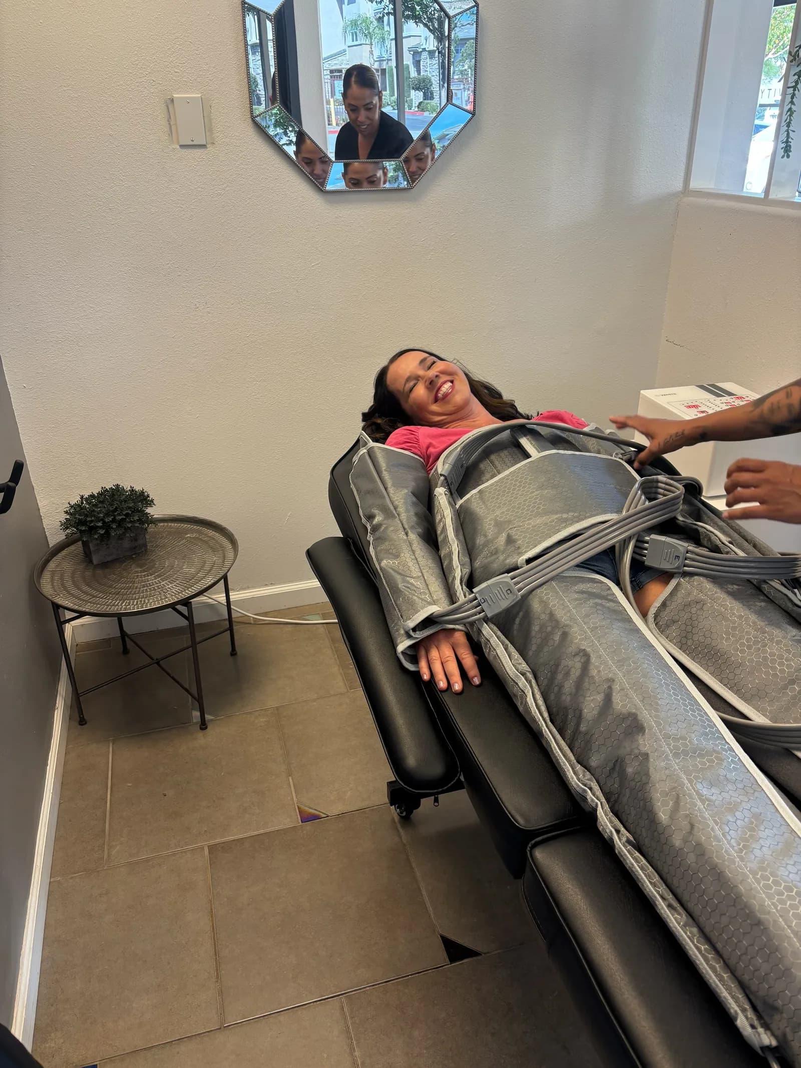 SK Longevity team member adjusting a full-body compression suit on a reclined client.