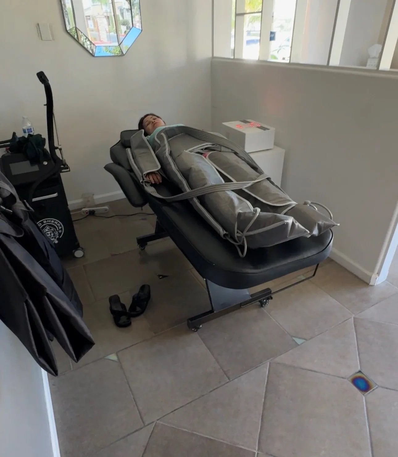 Client resting in a full-body compression suit on a treatment chair at SK Longevity.